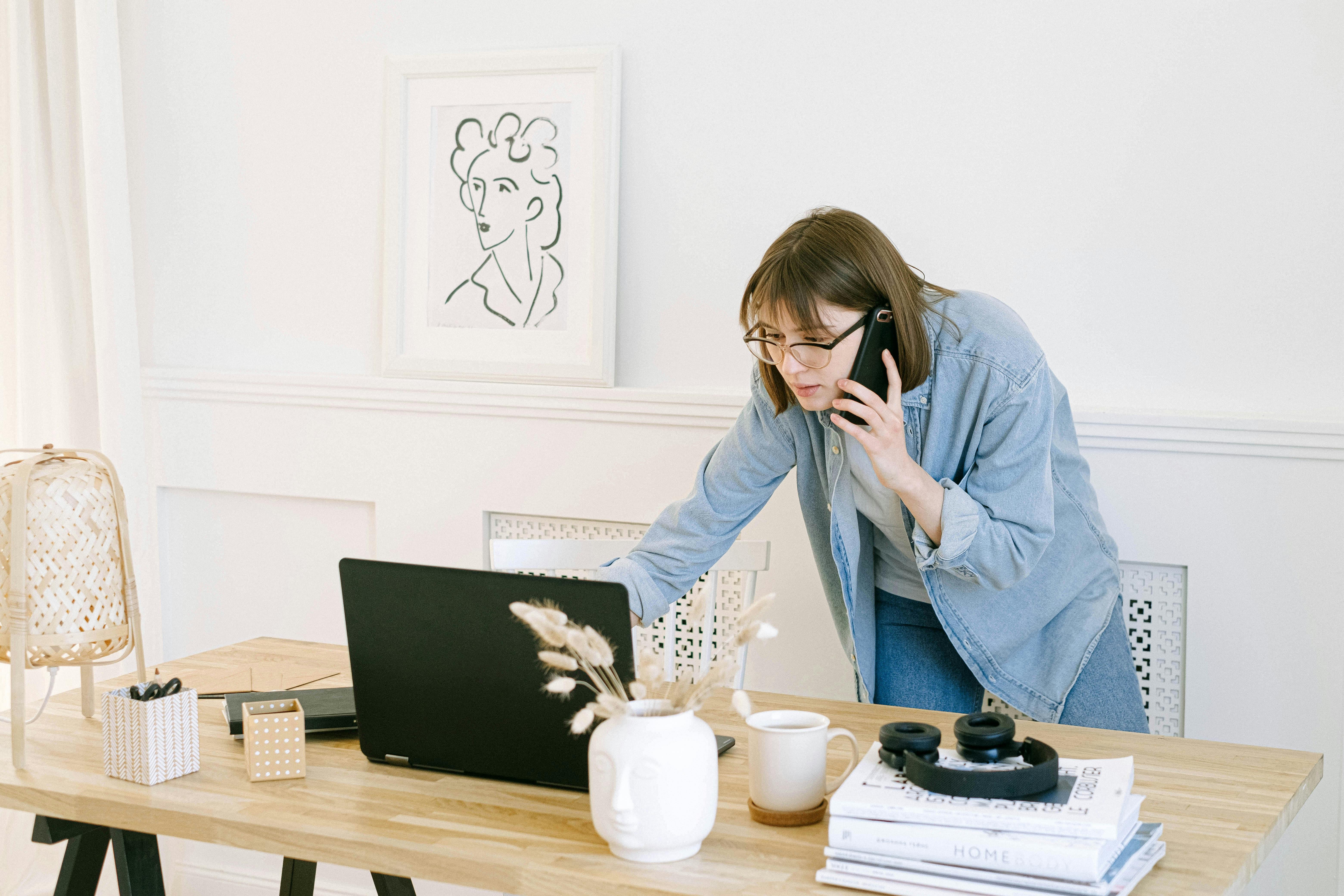 Lady standing behind a desk holding a phone to her ear as she tries to hire the copywriter